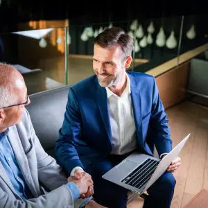 younger and older businessman shaking hands in mod UGE522P