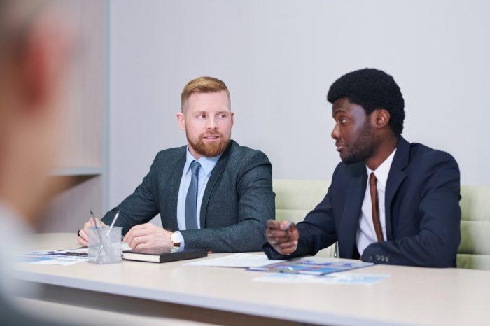 two young intercultural businessmen discussing